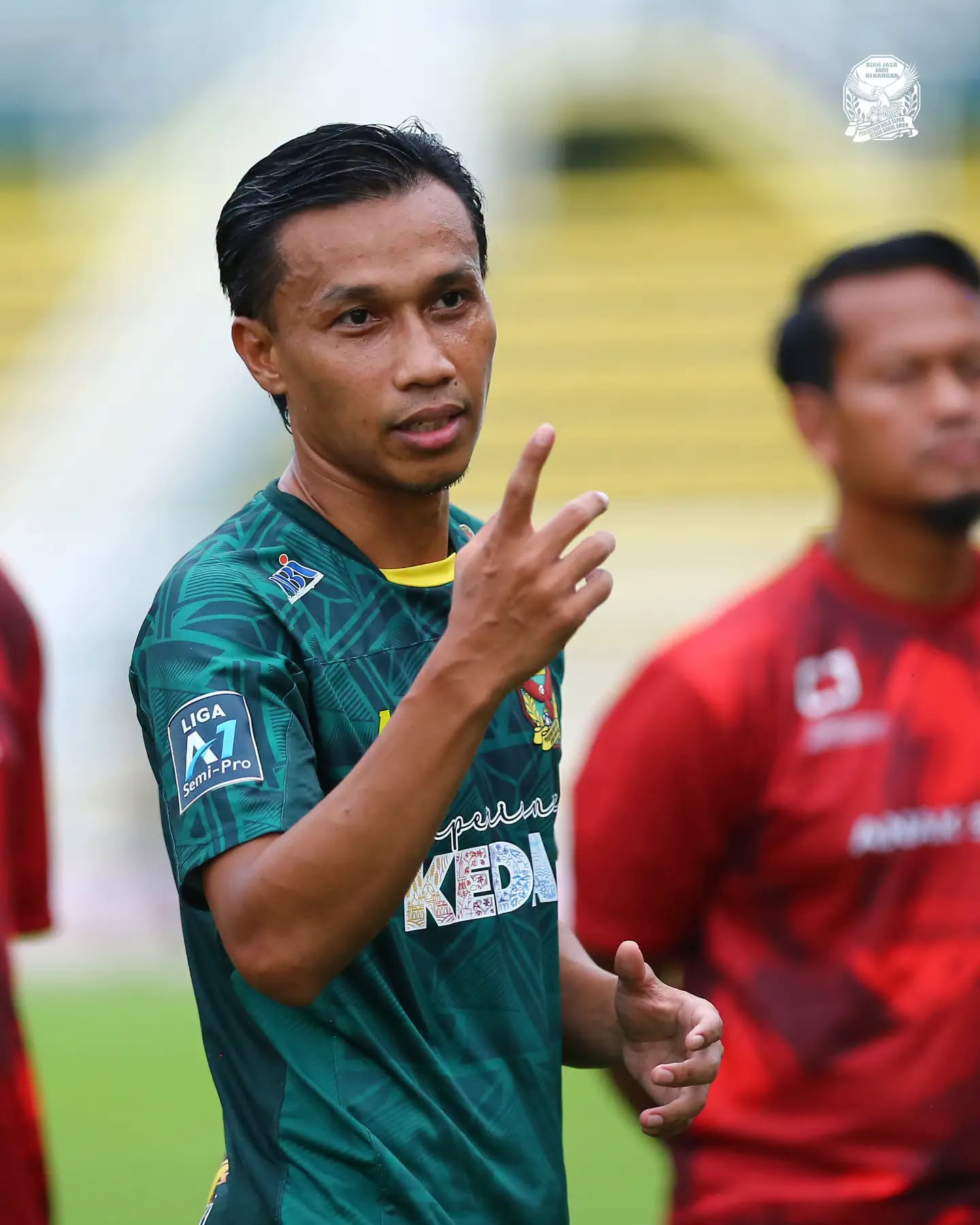 Baddrol Bakhtiar in a green Kedah shirt on the pitch, gesturing to someone off camera